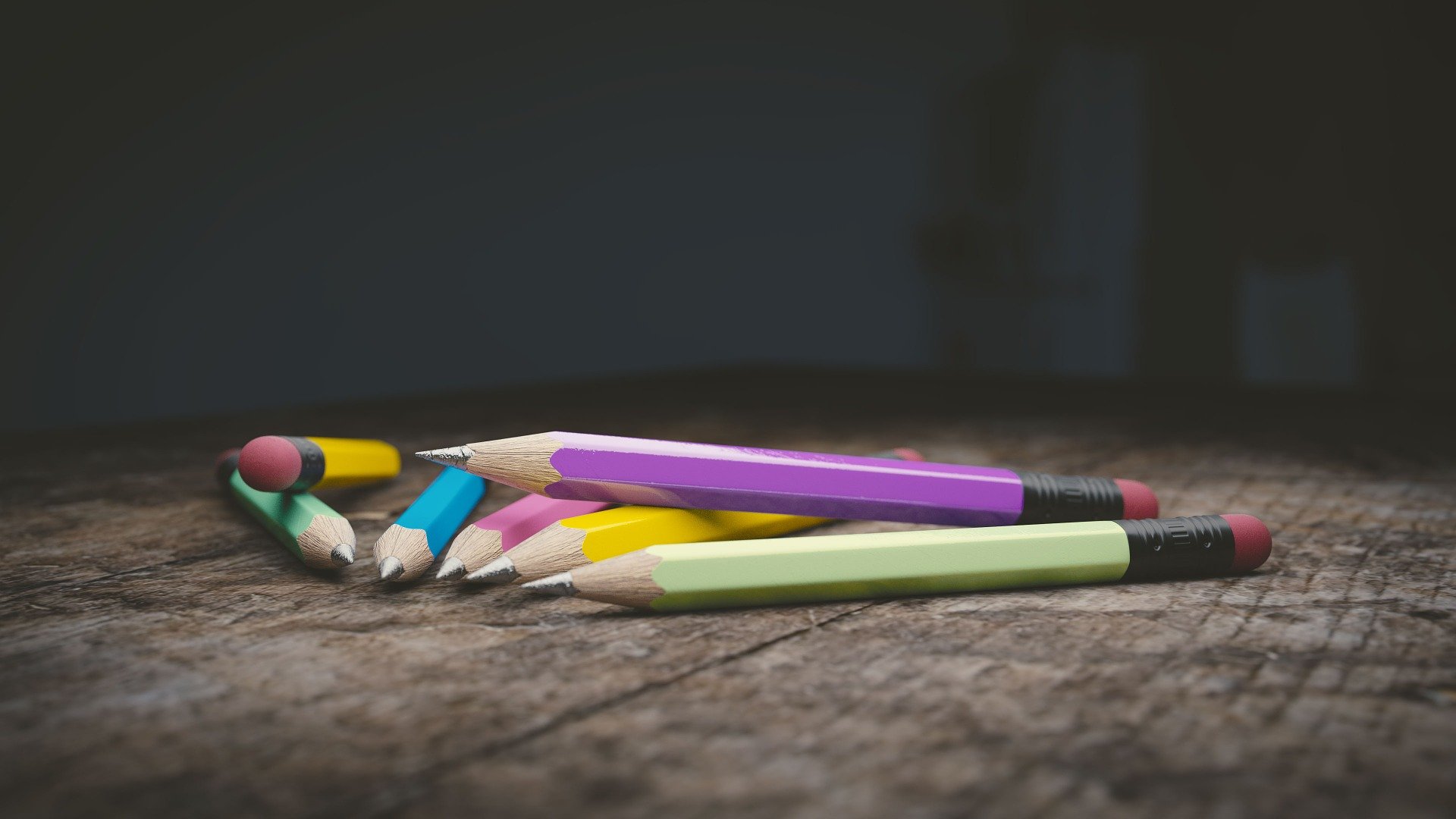 Des crayons à papier de couleurs vives sur une table en bois